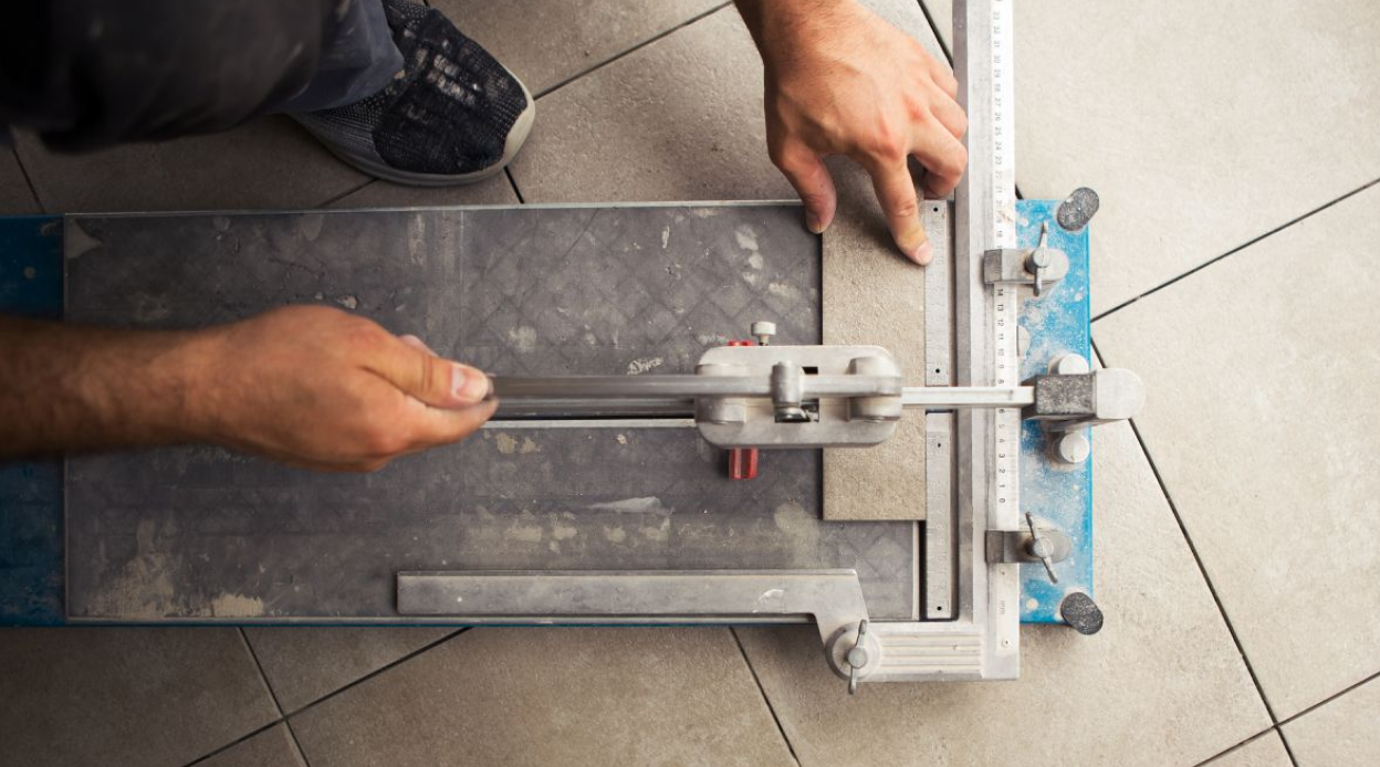 Fliesenschneider-Hero-1 Fliesenschneider auf dem Boden in Verwendung beim Schneiden einer kleinen Leiste